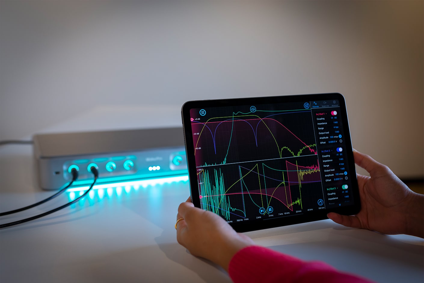 Woman holding tablet showing Frequency Reponse Analyzer in software UI